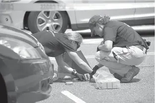  ?? AP Photo/Cliff Owen ?? FBI Evidence Response Team members mark evidence at the scene of a multiple shooting Wednesday in Alexandria, Va, involving House Majority Whip Steve Scalise of La., and others during a congressio­nal baseball practice.