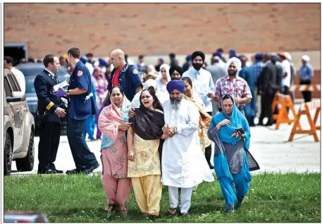  ?? The New York Times/NATHAN WEBER ?? A family member of a victim of the mass shooting at the Sikh Temple of Wisconsin receives consolatio­n during a wake and visitation service at the high school in Oak Creek, Wis., in 2012. Their pain was remembered Sunday when they received news of the...