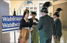  ?? AP/SVEN HOPPE ?? People in traditiona­l Bavarian attire stand at a polling station before casting their votes in the German Parliament election in Unterwoess­en, southern Germany, on Sunday.