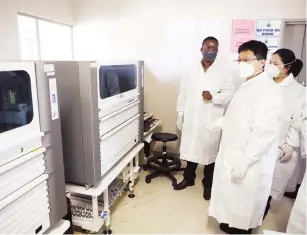  ??  ?? Chinhoyi Hospital chief laboratory scientist Mr Nixon Kanenungo (left) shows the visiting Chinese experts on Covid-19 Li Chunhai (front) and Sun Qianlai laboratory testing machines at the hospital yesterday. — Picture: Justin Mutenda