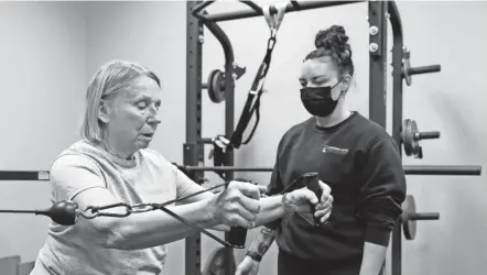  ?? BARBARA J. PERENIC/COLUMBUS DISPATCH ?? Mo Golde works with Marcia Ouellette, 80, at Personal Level Fitness. Ouellette has trained at Personal Level Fitness for the last 13 years and appreciate­s their one-on-on business model.