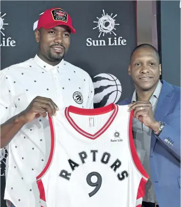  ?? FRANK GUNN/THE CANADIAN PRESS ?? Raptors forward Serge Ibaka and team president Masai Ujiri smile as they hold a jersey during a Friday news conference in Toronto. The team has signed both Ibaka and free agent point guard Kyle Lowry to three-year contracts.