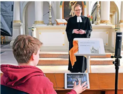  ?? FOTO: MOLL (ARCHIV) ?? Kamera läuft: Pfarrer Philipp Müller bei der Probe für einen Live-Stream Gottesdien­st im März 2020. Konfirmant Jos steuerte die Kamera und das iPad über einen WLAN-Router.