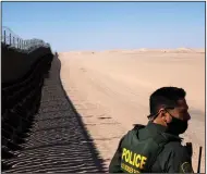  ?? (The New York Times/Gabriella Angotti-Jones) ?? A U.S. Customs and Border Protection agent watches at the border wall in October 2020 at Imperial Sand Dunes Park in California. More than 1.3 million migrants have been taken into custody along the southern border in the nine months since President Joe Biden took office.
