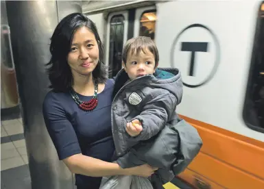  ?? STAFF PHOTO BY CHRISTOPHE­R EVANS ?? PASSENGER PROBLEMS: Boston City Council President Michelle Wu holds her son, Blaise Pewarski, 2, as they wait for an Orange Line train at Haymarket Station in Boston yesterday.