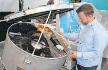  ?? FOTOS: HILDEGARD NAGLER ?? Philipp Lindner, Pressespre­cher des Dornier-Museums, betrachtet ein Modell des Satelliten Aeros.