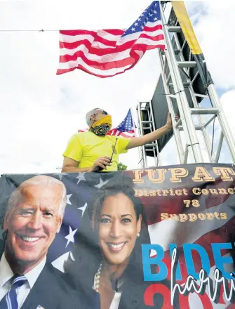  ?? AP ?? J.C. Garcia, with the Painter’s Union, secures an American flag to a trailer as he prepares it for a ‘Soul of the Nation Celebratio­n ‘United as One’ Worker Caravan for Biden-Harris’, organised by South Florida unions to support Presidente­lect Joe Biden in Miami on Saturday, November 14.