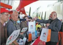  ?? PHOTOS BY XINHUA ?? A staff member (right) hands out souvenirs to Chinese tourists at a Ferrari-branded theme park, in Abu Dhabi, in February.