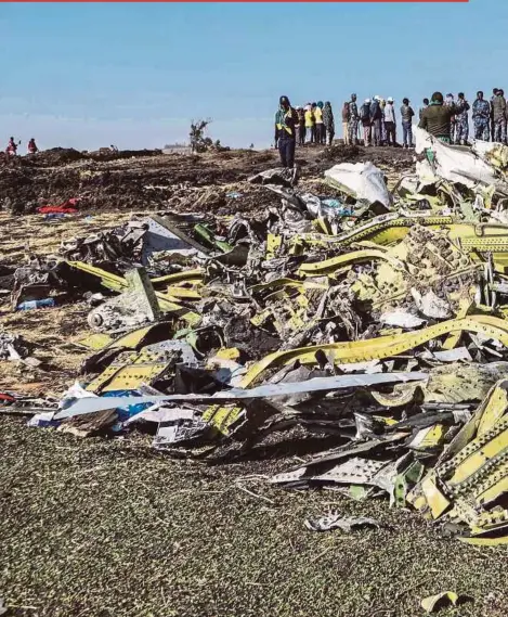  ?? AFP PIC ?? People standing near collected debris at the crash site of an Ethiopia Airlines plane near Bishoftu, Ethiopia, yesterday.