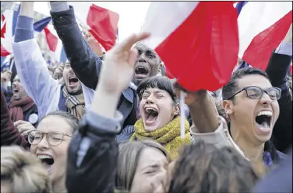  ?? LAURENT CIPRIANI / ASSOCIATED PRESS ?? Supporters of French independen­t centrist presidenti­al candidate Emmanuel Macron react outside the Louvre museum in Paris, France, on Sunday. French voters delivered a resounding victory for Macron, a 39-year-old former investment banker and political...