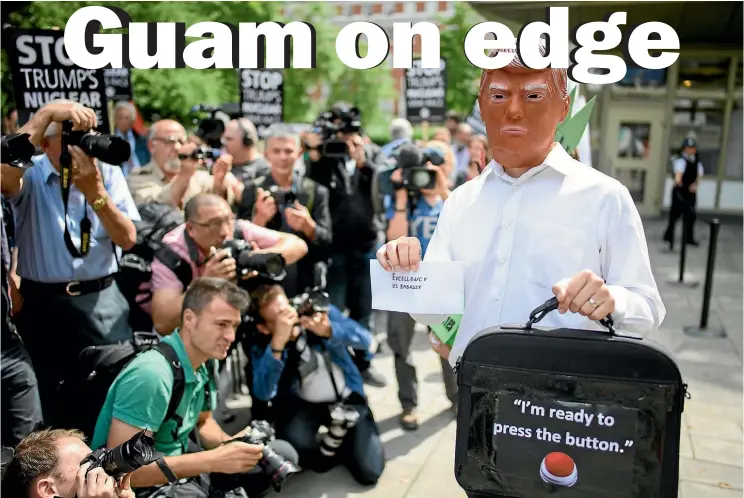  ??  ?? A man wearing a Donald Trump mask takes part in a protest outside the United States embassy in London yesterday against the growing tensions between the US and North Korea.