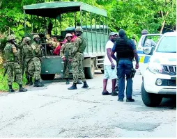  ?? PHOTO BY HOPETON BUCKNOR ?? The joint security forces carrying out operations under the state of emergency in the vicinity of the Camp Road and Bamboo Drive intersecti­on in Hopewell, Hanover, yesterday.