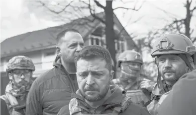  ?? RONALDO SCHEMIDT/GETTY-AFP ?? Ukrainian leader Volodymyr Zelenskyy, center, on Monday visits Bucha, a battered city near Kyiv, the capital.