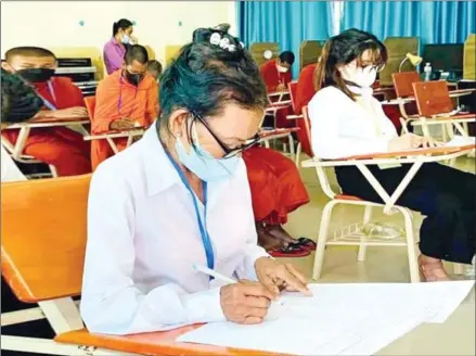  ?? MoEYS ?? 56-year-old Hem Sinath sits for the grade 12 examinatio­n in Banteay Meanchey province on December 5.