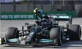  ?? Photograph: Nelson Almeida/AFP/Getty Images ?? Lewis Hamilton was fined after taking off his seatbelt to accept a Brazilian flag on his inlap after his momentous victory.