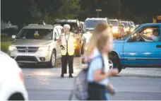  ?? STAFF PHOTO BY ROBIN RUDD ?? School Patrol officer Priscilla Taggart, a 46-year veteran of the patrol, directs children and vehicles at the intersecti­on of Tombras Avenue and Bennett Road in front of the East Ridge High and Middle school campus on Wednesday.