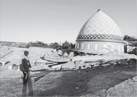  ?? TATAN SYUFLANA THE ASSOCIATED PRESS ?? Locals view the devastatio­n of a collapsed Jamiul Jamaah Mosque in Bangsal, North Lombok, Indonesia, on Wednesday. The north of Lombok was devastated by the powerful quake that struck Sunday night. Lombok was also hit with an earthquake on July 29.