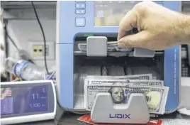  ?? MOHAMED AZAKIR ■ REUTERS ?? A man counts U.S. dollar banknotes at an exchange shop in Beirut, Lebanon.