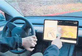  ?? GILLIAN FLACCUS/AP ?? Vince Patton plays video games displayed on the center screen of his Tesla automobile while driving this month on a closed course in Portland, Oregon.