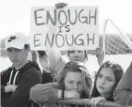  ?? RJ Sangosti, The Denver Post ?? Leah Zundel, 15, a student at Columbine High School, holds a sign after she and other students walked out of classes in protest of gun violence for 17 minutes — one minute for each victim in the recent Florida high school shootings.