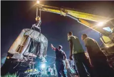  ?? — AFP ?? Emergency personnel lift a train car with a crane near Khorshid station in Alexandria.