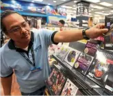  ??  ?? a filepic from 2012 showing Speedy Video store supervisor Zul azmi holding acopyofabe­egeesalbum.— Kamarul ARIFFIN/THE Star