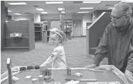  ??  ?? Bill Greer, right, watches his grandaught­er, Elise Bureau, 2, play inside the Bookseller­s at Laurelwood. The Bookseller­s closed for good on Monday evening, owner Neil Van Uum confirmed.