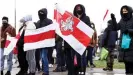  ??  ?? Opposition supporters holding former white-red-white flags of Belarus