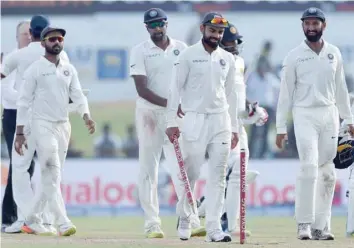  ?? — AFP ?? Indian captain Virat Kohli (C) and team-mates leave the pitch after the fourth day of the first Test against Sri Lanka at Galle Internatio­nal Cricket Stadium in Galle. Virat Kohli’s India thrashed Sri Lanka by 304 runs inside four days to claim the first Test in their three-match series.