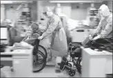  ?? XINHUA ?? From left: Doctors accompany an 81-year-old patient to a CT scan at Huoshensha­n Hospital.