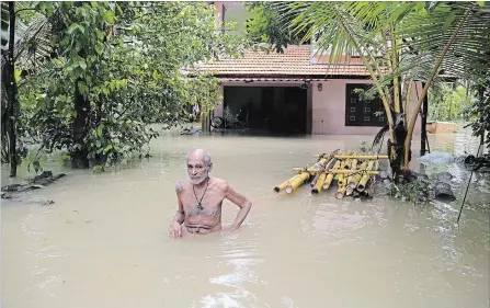  ?? AIJAZ RAHI THE ASSOCIATED PRESS ?? A man wades through flood waters to a boat carrying food in Kerala, India, Sunday. Hundreds have died in Kerala in the worst flooding in a century.