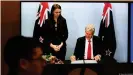  ??  ?? El ministro de Comercio de Nueva Zelanda, Damien O'Connor, firma en Wellington. La primera ministra Jacinda Ardern, a la izquierda