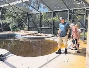  ?? LAUREN RITCHIE/STAFF ?? John Simmons, 43, and his two children, Todd and Ivy, check the family pool — which filled with raw sewage when the septic tank at their rental home flooded during hurricane Irma.