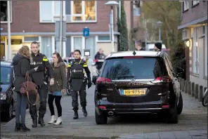  ?? AP/PETER DEJONG ?? Dutch police stand guard Monday outside a house where the suspect of a shooting in a tram was arrested in Utrecht, Netherland­s.