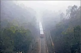  ?? Channi Anand
Associated Press ?? A PASSENGER train is shrouded on the outskirts of Jammu, India. There’s no need for an onboard announceme­nt: It’s winter. There’s fog. We’re late.