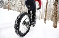  ??  ?? A fat tire bicyclist rides on a cross country ski trail during a race at the Sugarloaf ski resort in Carrabasse­tt Valley, Maine.