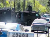  ?? Austin Dave/The Signal ?? Heavily armed sheriff’s deputies take positions near a house in Newhall. A man barricaded in the home was arrested.