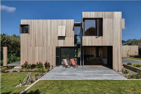  ??  ?? ABOVE Instead of a single entrance door, large sliders from APL’s Architectu­ral Series create several informal entryways on all sides of this coastal home. Upstairs, a combinatio­n of playfully positioned picture windows by First Windows & Doors and top-hung shutters punctuates the building’s rectangula­r forms. OPPOSITE Protruding sunshades surround the black anodised joinery by First Windows & Doors.