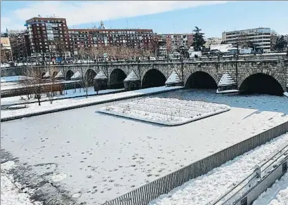  ?? RICARDO RUIZ / EFE ?? Vista del río Manzanares y el puente de Segovia, en Madrid, al mediodía de ayer. Las bajas temperatur­as, más altas de las que se prevén a partir de hoy, congelaron gran parte del río