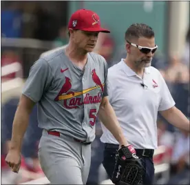  ?? JEFF ROBERSON — THE ASSOCIATED PRESS ?? Cardinals starting pitcher Sonny Gray, left, walks off the field with trainer Adam Olsen after being removed during the second inning of a spring training game against the Nationals on Monday in West Palm Beach, Fla.