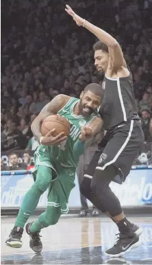  ?? STAFF PHOTO BY STUART CAHILL ?? CARRYING THE LOAD: Kyrie Irving drives to the basket against Spencer Dinwiddie during the second half of the Celtics’ victory against Brooklyn last night.