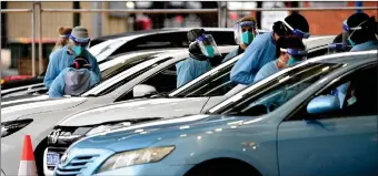  ?? Photo: Nampa/AFP ?? Resurgence… Health workers take swab samples from residents at a Covid-19 drivethrou­gh testing clinic in Sydney’s Fairfield suburb on 14 July 2021.