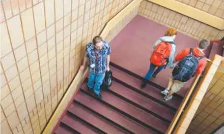  ??  ?? Joshua Plunkett holds the handrail while descending the stairs at Horizon High School in Thornton in May. Joshua doesn’t like anything thatmoves, and he has claustroph­obia, so the school elevator is not an option. But he is not fond of stairs either....