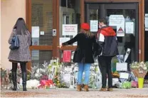  ?? MICHEL EULER AP ?? People stand by a memorial Saturday created outside the school where a slain history teacher had worked in France.