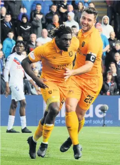  ??  ?? Delight Dolly Menga wheels away with Craig Halkett after scoring