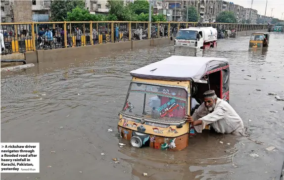  ?? Fareed Khan ?? A rickshaw driver navigates through a flooded road after heavy rainfall in Karachi, Pakistan, yesterday