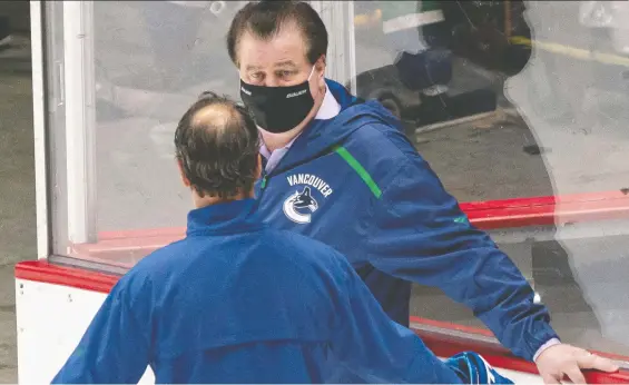  ?? RICHARD LAM ?? Canucks general manager Jim Benning, shown speaking with a member of the coaching staff at training camp, says he isn't ready to give up on the season just yet.