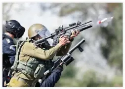  ??  ?? Israeli soldiers fire teargas canisters during clashes with Palestinia­n protesters in the West Bank town of Tulkarem on Sunday. (AP)