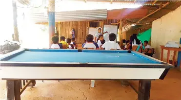  ?? CORTESÍA ?? Una mesa de billar en primer plano y un grupo de los pequeños alumnos en la hora de clase.