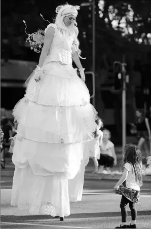  ?? ZHOU DAN / XINHUA ?? An actor dressed as giant fairy entertains a small girl during a Christmas parade in Perth, Australia, on Saturday.